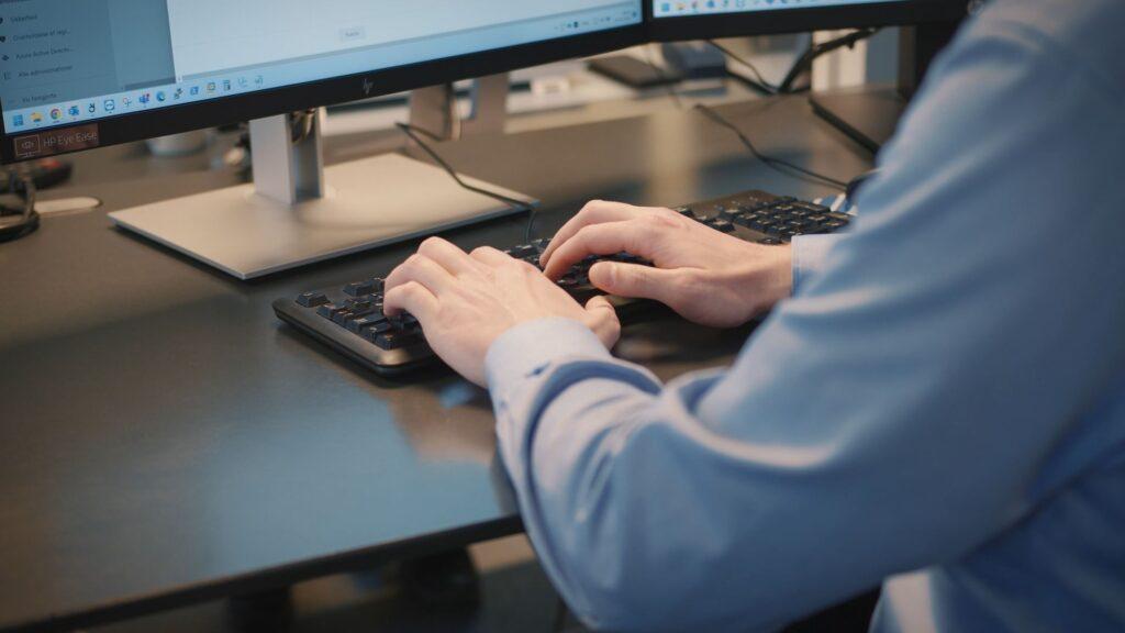 En PM-solutions medarbejder der skriver på et tastatur 2
